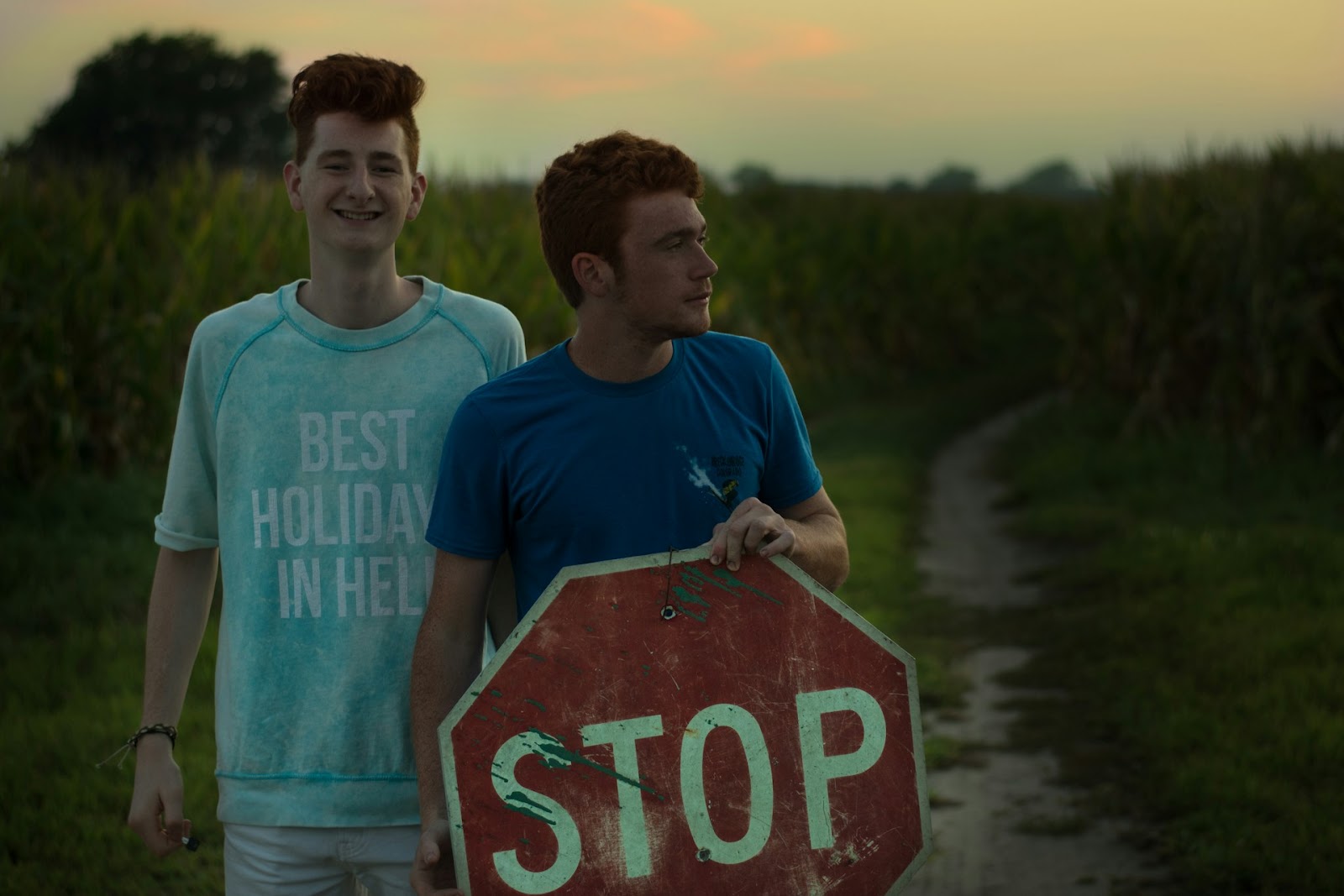 Two men standing next to a stop sign