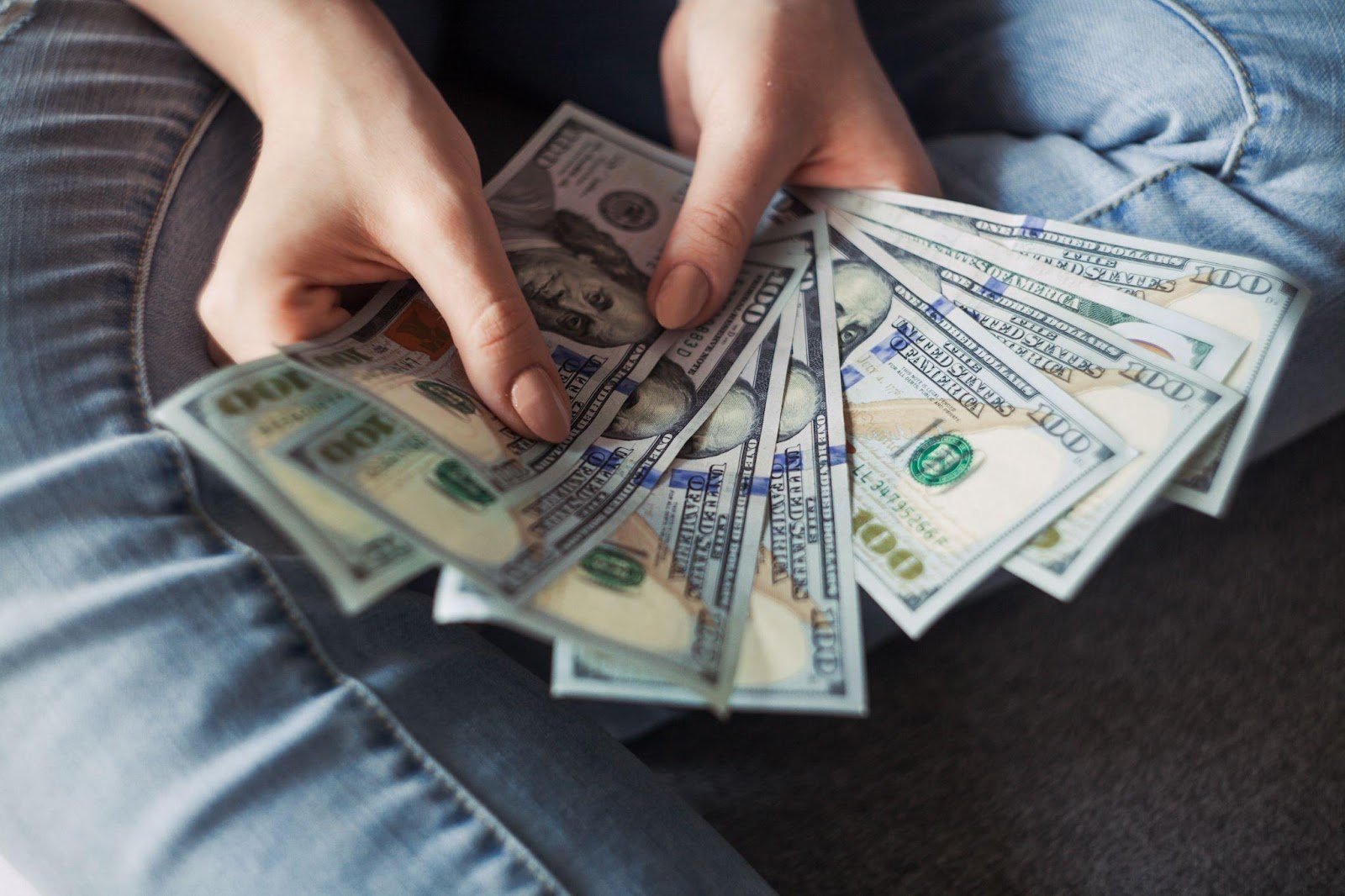 A man holding a stack of new $100 bills