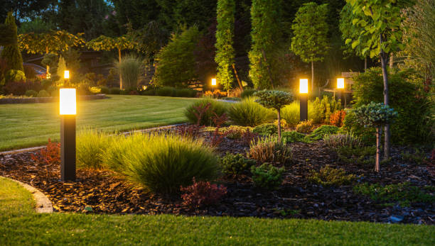 Modern Backyard Outdoor LED Lighting Systems Panoramic Photo of LED Light Posts Illuminated Backyard Garden During Night Hours. Modern Backyard Outdoor Lighting Systems. outdoor lighting backyard stock pictures, royalty-free photos & images