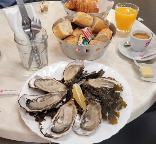 A plate of oysters and bread on a table

Description automatically generated