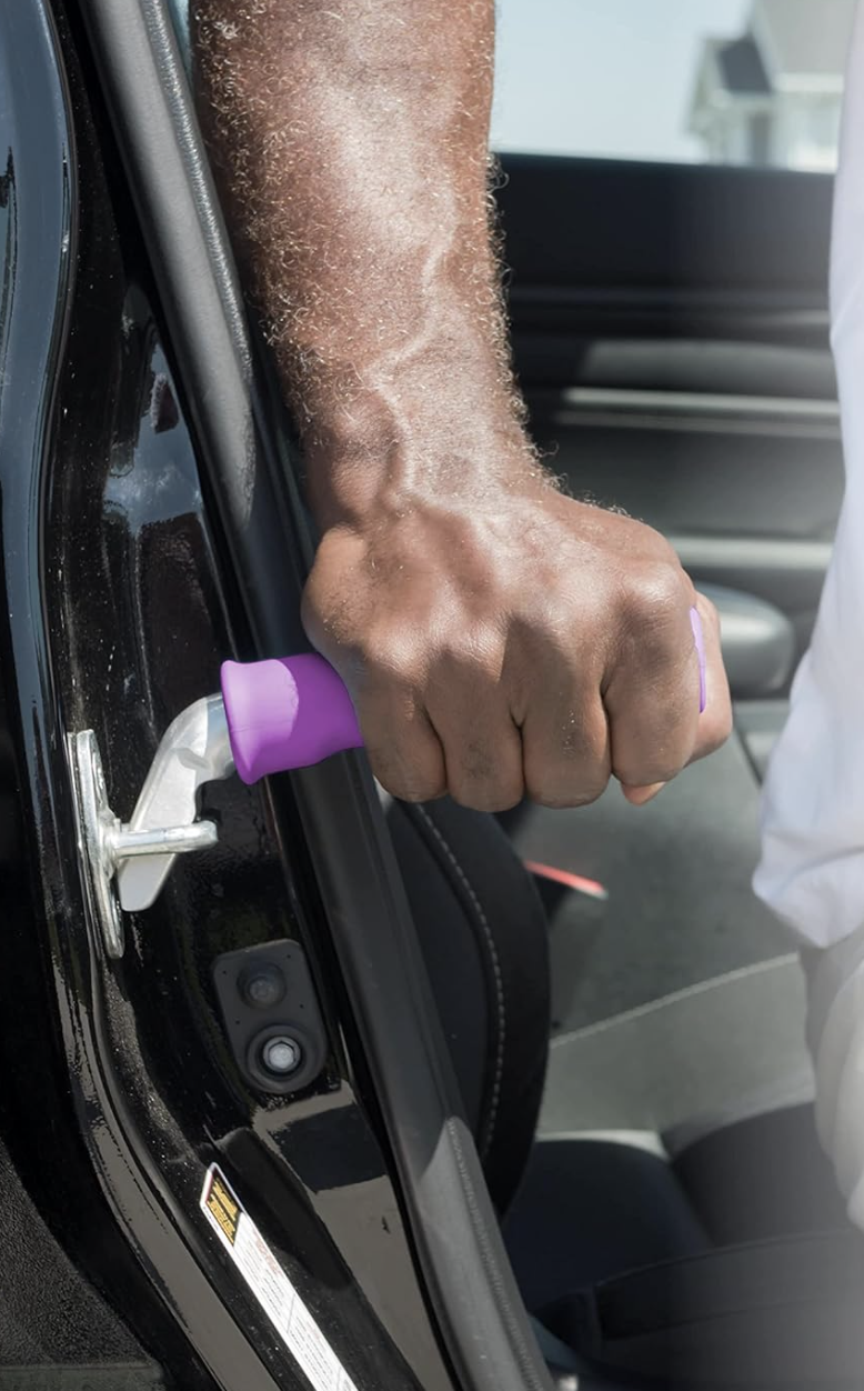 a hand holing a purple handle getting out of a car