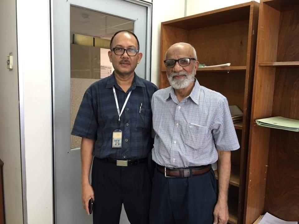 Two men standing in front of a door

Description automatically generated