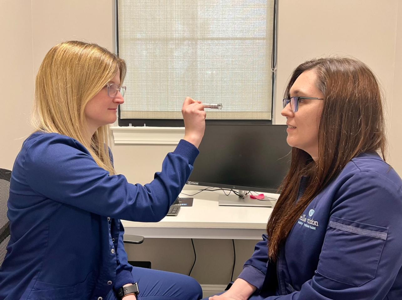 Stephanie is using a synotics pen light to help Kristen work through basic eye movements.