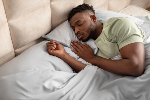 homem negro dormindo para se recuperar da ressaca de Carnaval - Assaí Atacadista