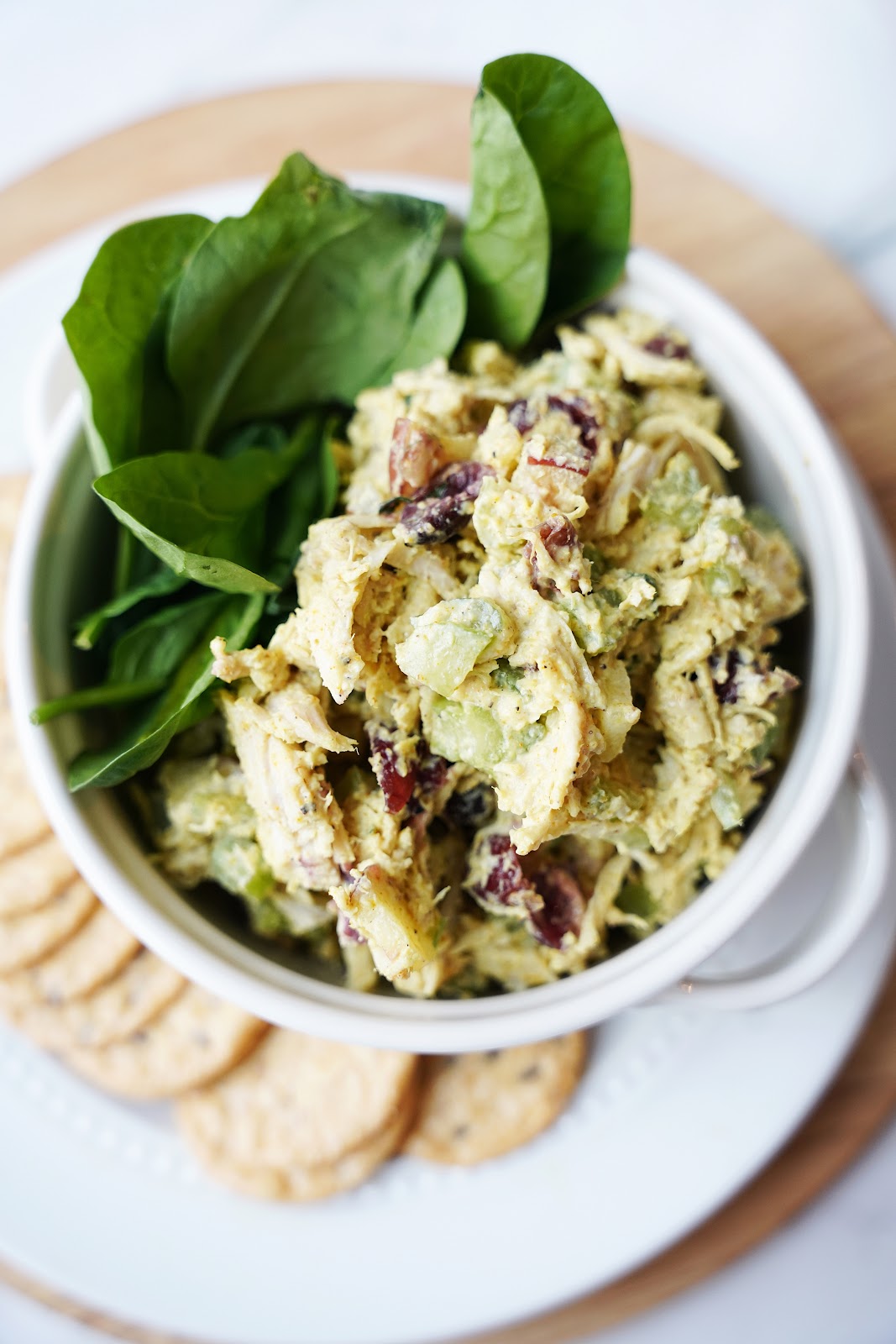 Curry chicken salad with apples in a bowl with crackers.