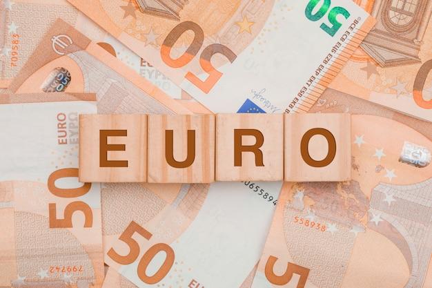 Free photo wooden cubes with word euro on banknote table .