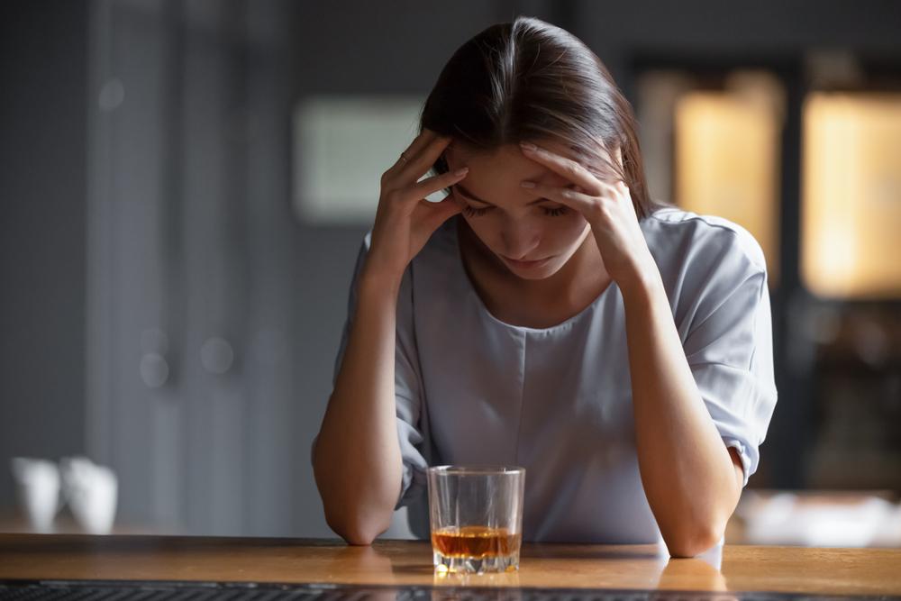 woman looking distressed deciding whether to drink alcohol 