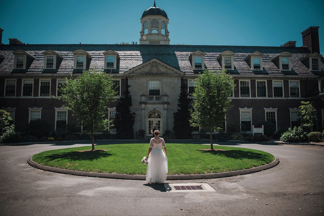 Bride standing outside of Oliver Ellsworth Homestead venue
