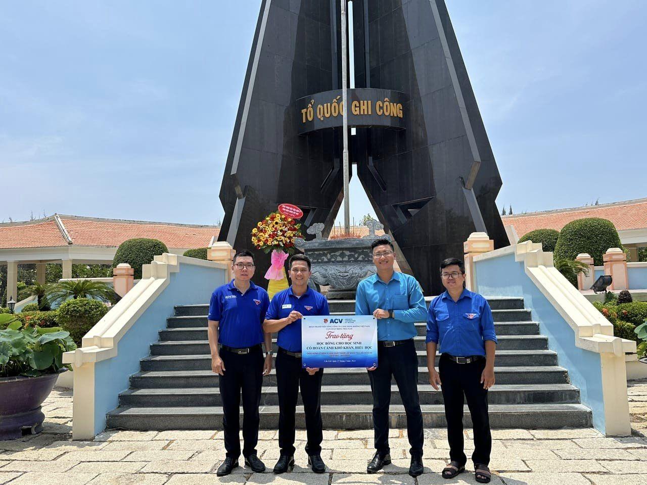 A group of men standing in front of a monumentDescription automatically generated