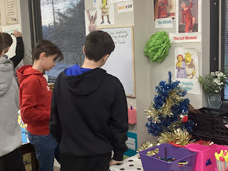 Middle School boys looking intently at work in front of a whiteboard