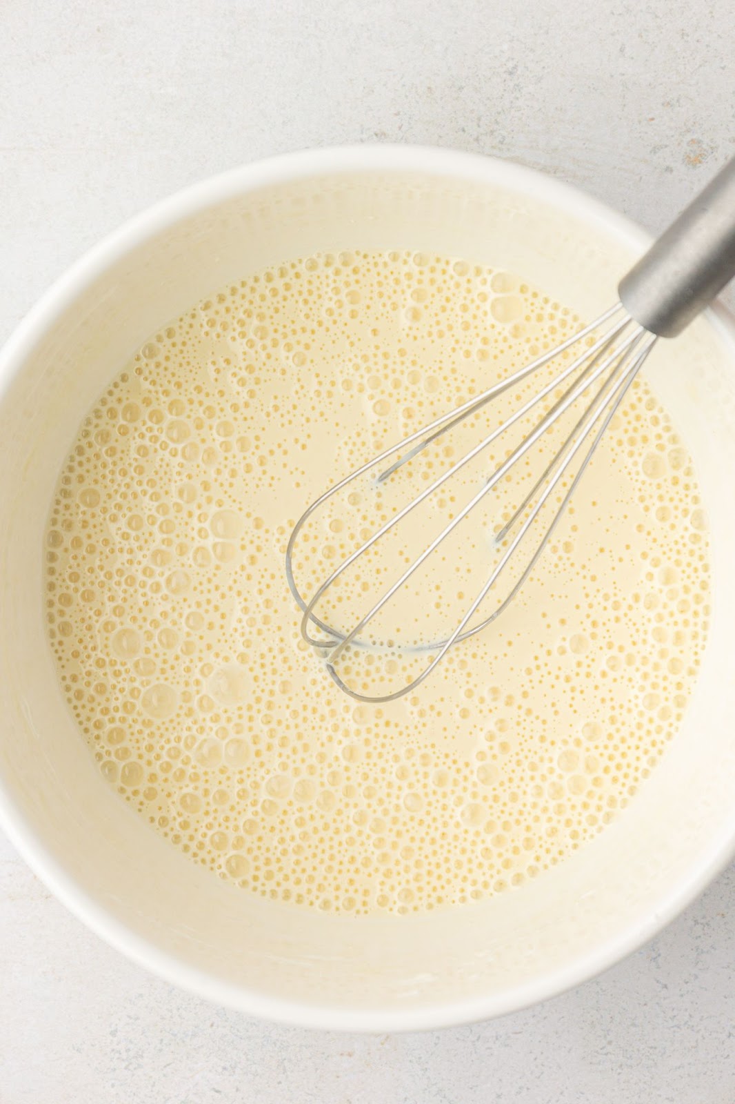bowl of pancake wet ingredients with a whisk