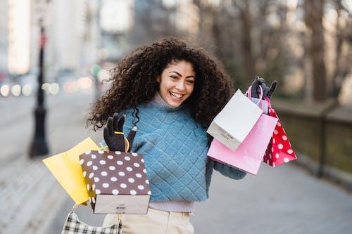 Free Cheerful shopper with bright gift bags smiling Stock Photo