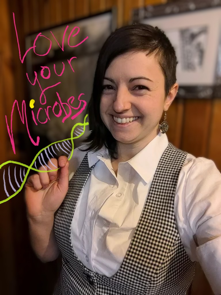 A headshot of Dr. Sue Ishaq, PhD in which she is wearing a black and white houndstooth pattern waistcoat and a white button up shirt. Graphics have been added to show a strand of DNA and the words "love your microbes"
