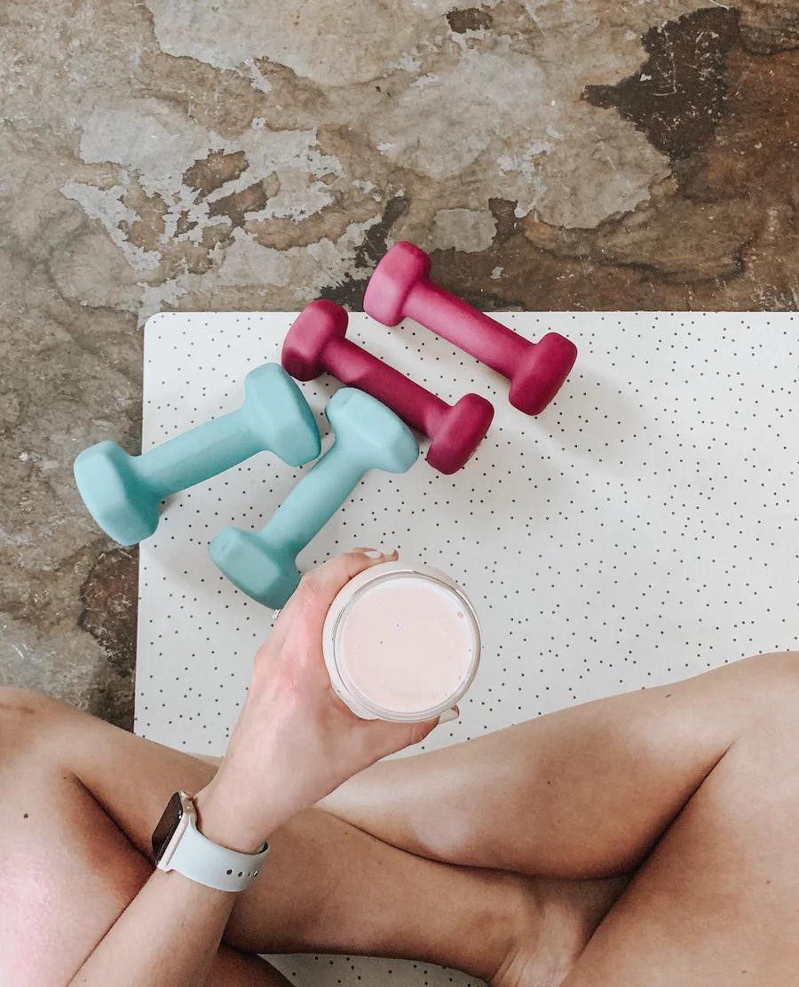 A woman holding a cup of mushroom coffee after workout  