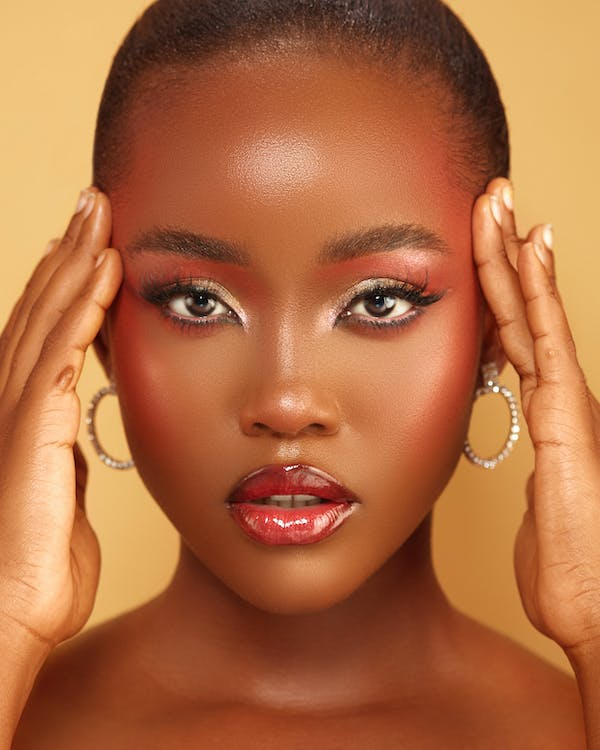 A woman posing for a headshot with focus on her makeup and hair