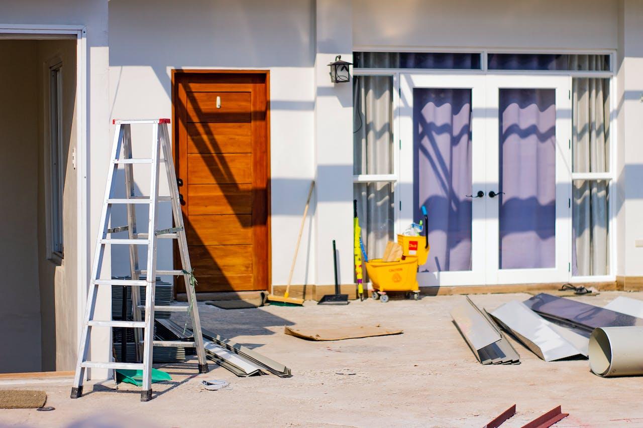 A ladder and tools outside of a house

Description automatically generated