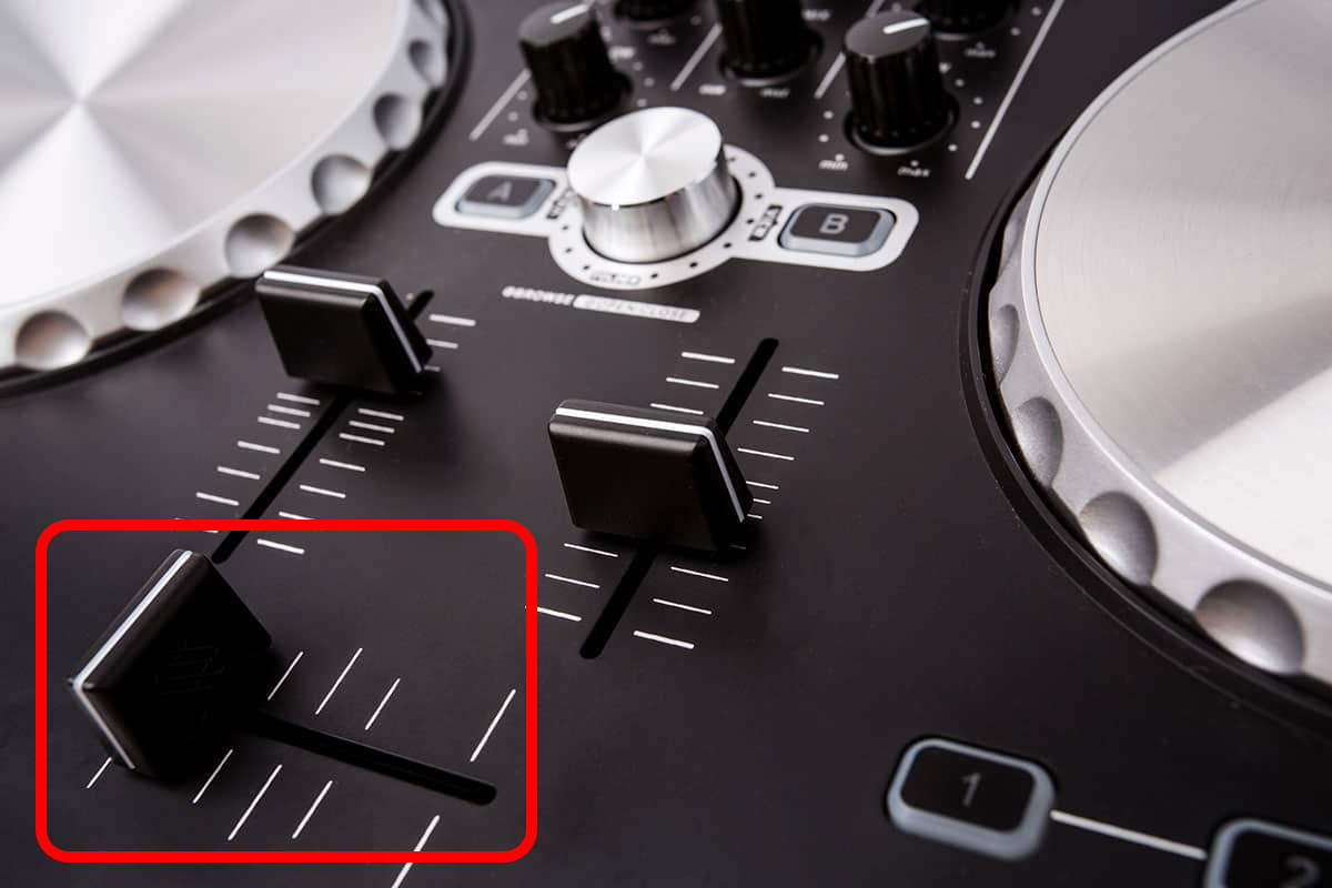 A photo of a DJ controller with a crossfader highlighted in red