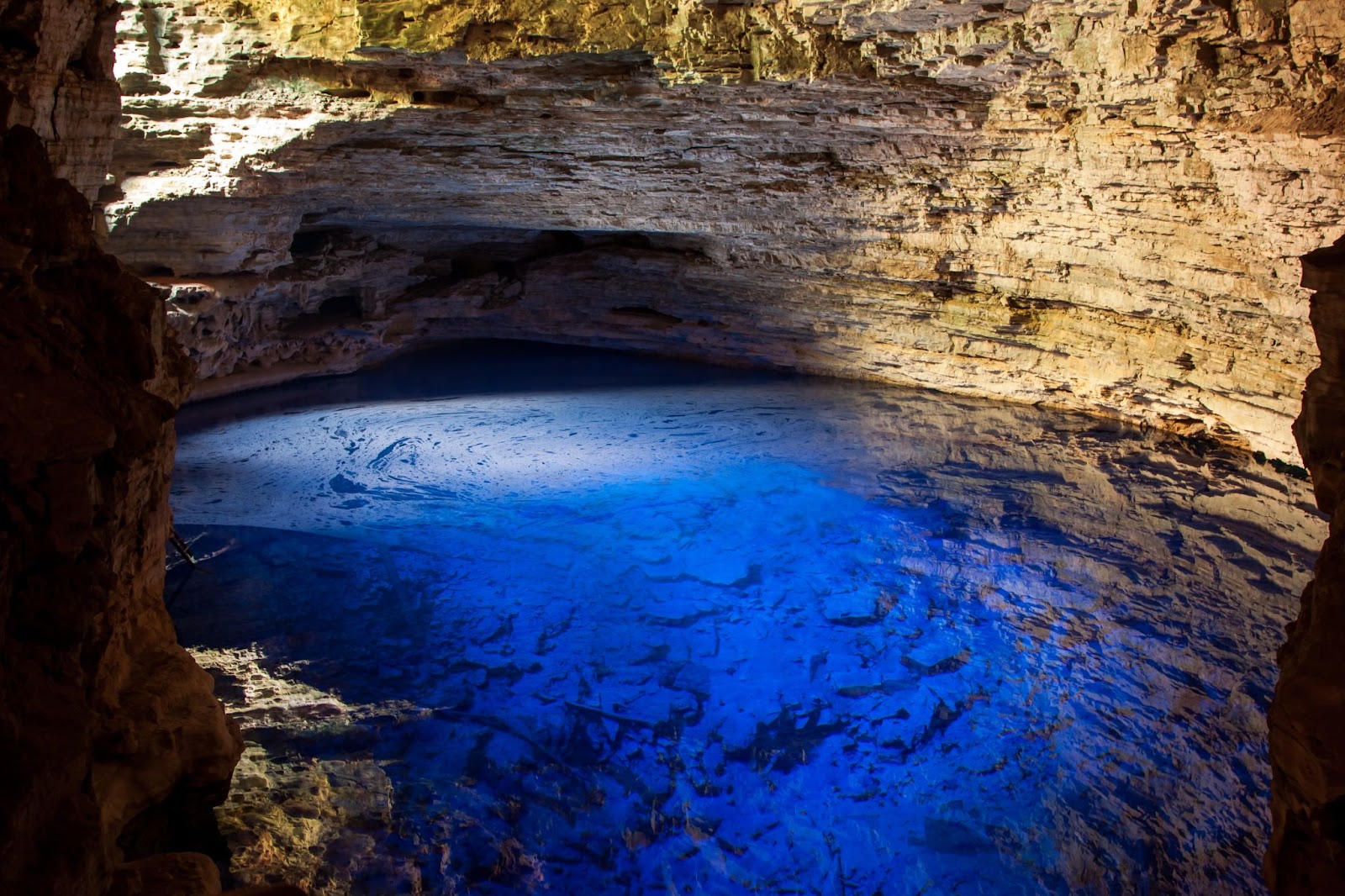 Poço de água azul dentro da Gruta Poço Encantado, na Chapada Diamantina