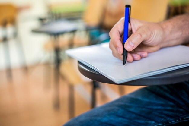 Foto grátis um homem está escrevendo / assinando um artigo. focada em uma mão com caneta