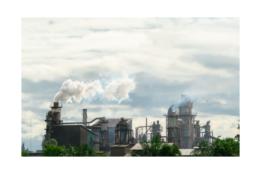 Factory buildings releasing smoke and greenhouse gases into the atmosphere.