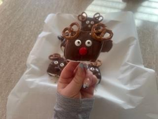 A hand holding a chocolate reindeer

Description automatically generated