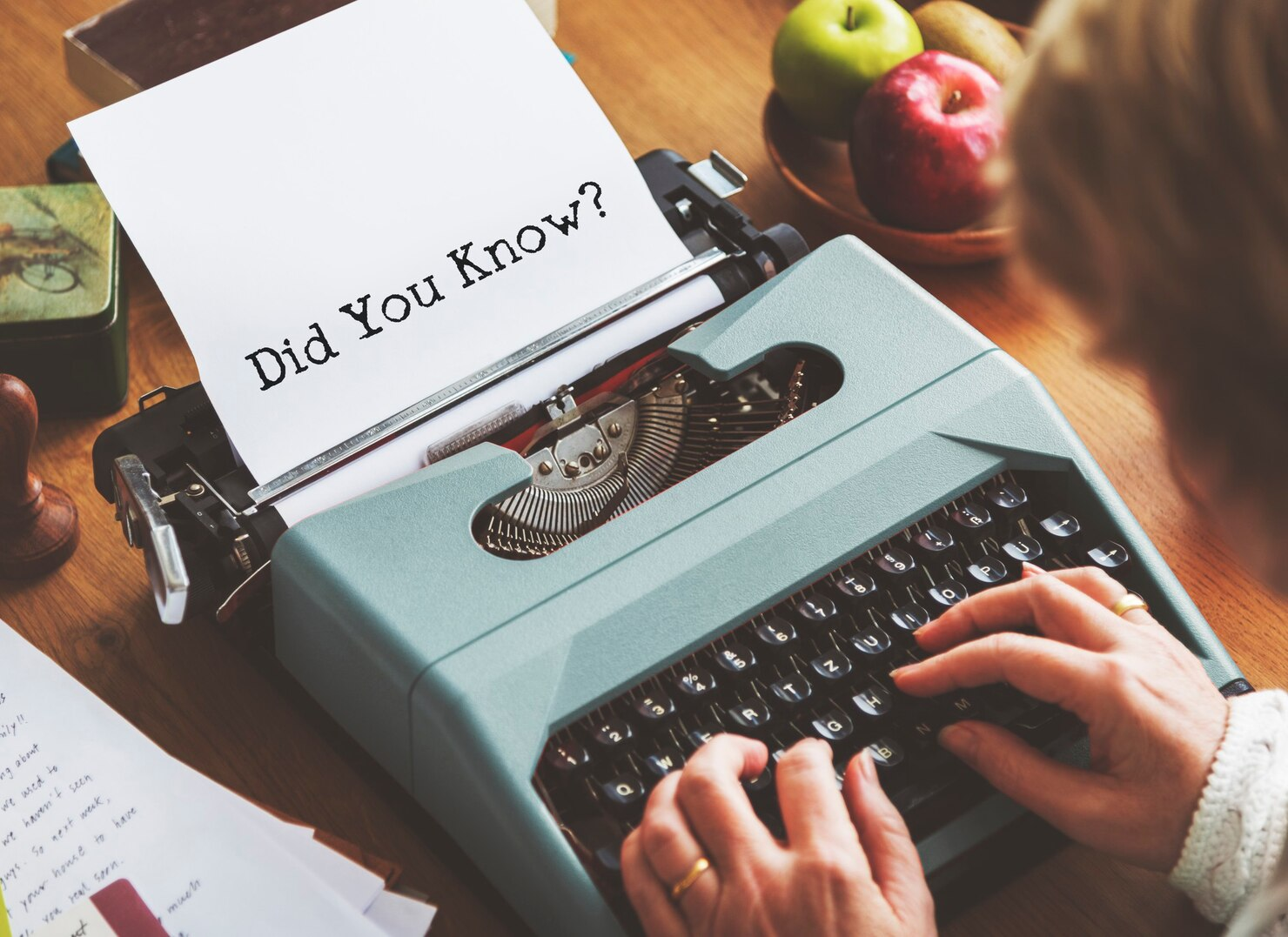 A woman using a typewriter to write a headline.