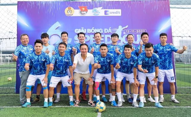 A group of men in blue shirts and shorts posing for a photo

Description automatically generated