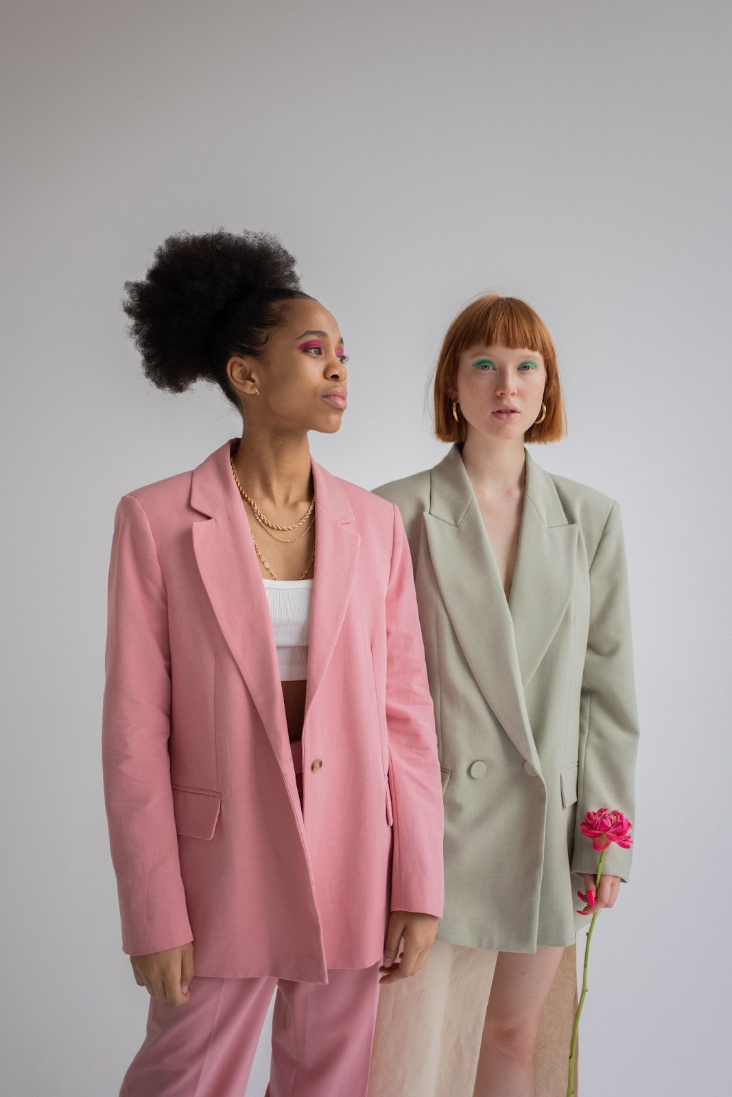 two women posing in blazers
