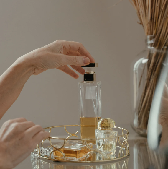 woman's hand reaching for a perfume bottle