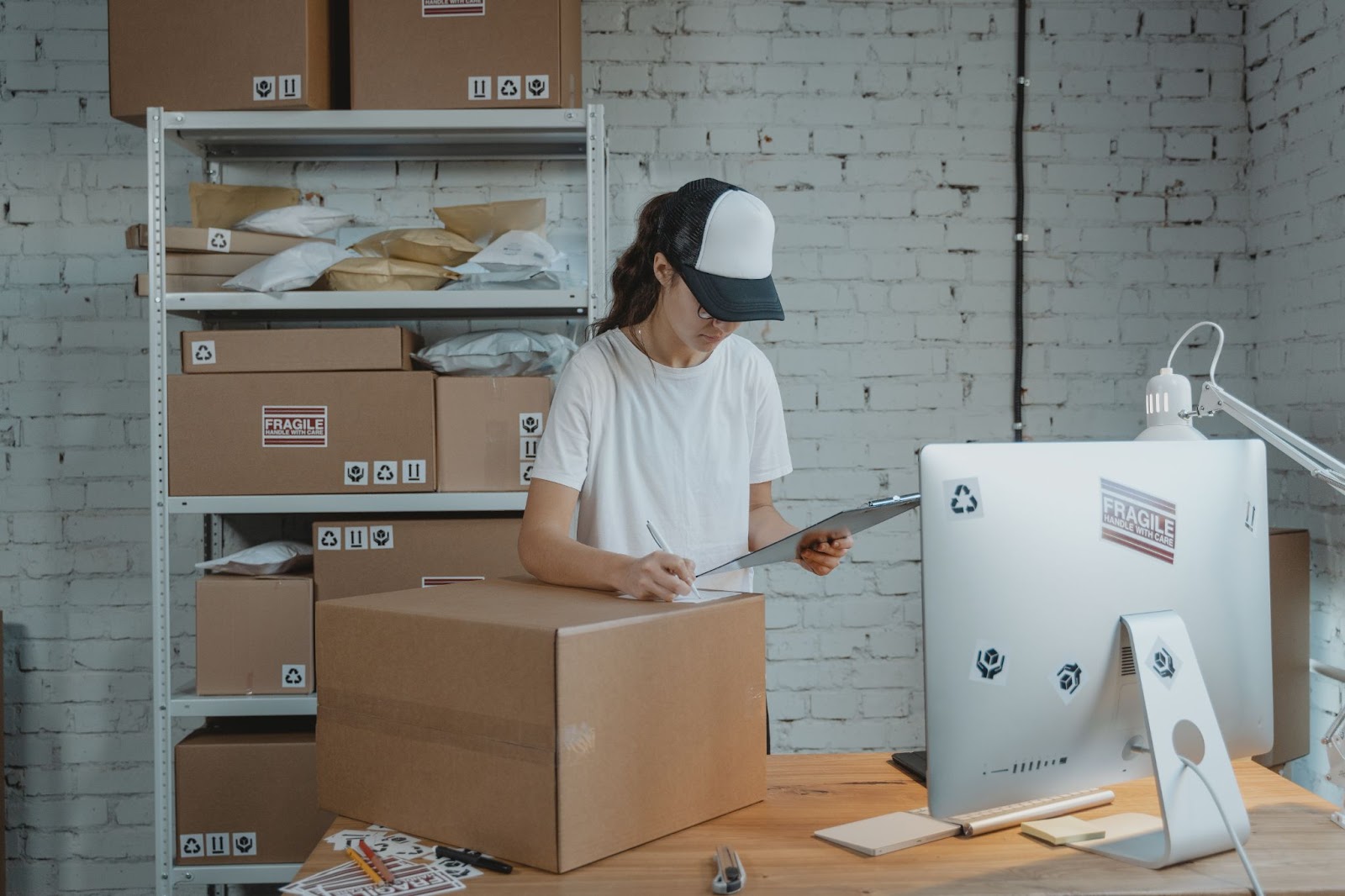 women looking at clipboard with a box on her desk