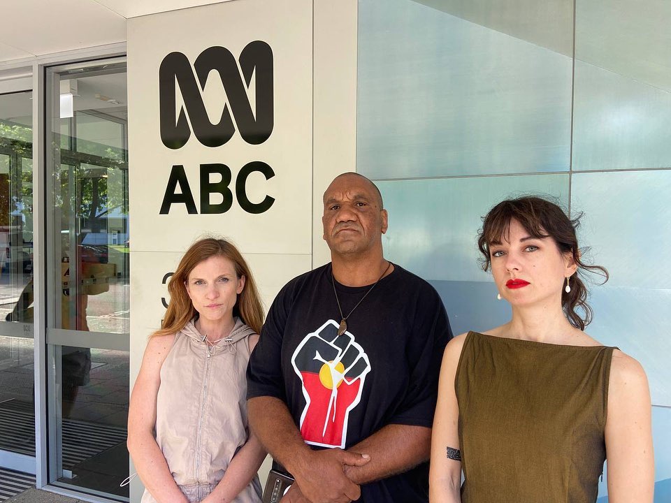 Three activists, one indigenous, stand outside an ABC studio