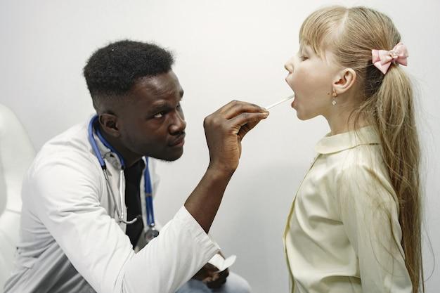 Médico de uniforme branco. homem com estetoscópio. garota com cabelo comprido.