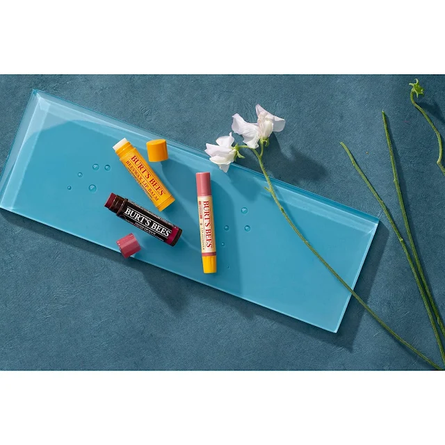 here are  3 pieces of burt,s bees lip balm, on glass & some flower