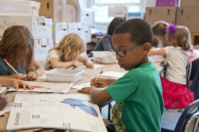 Children in a school classroom do assignments