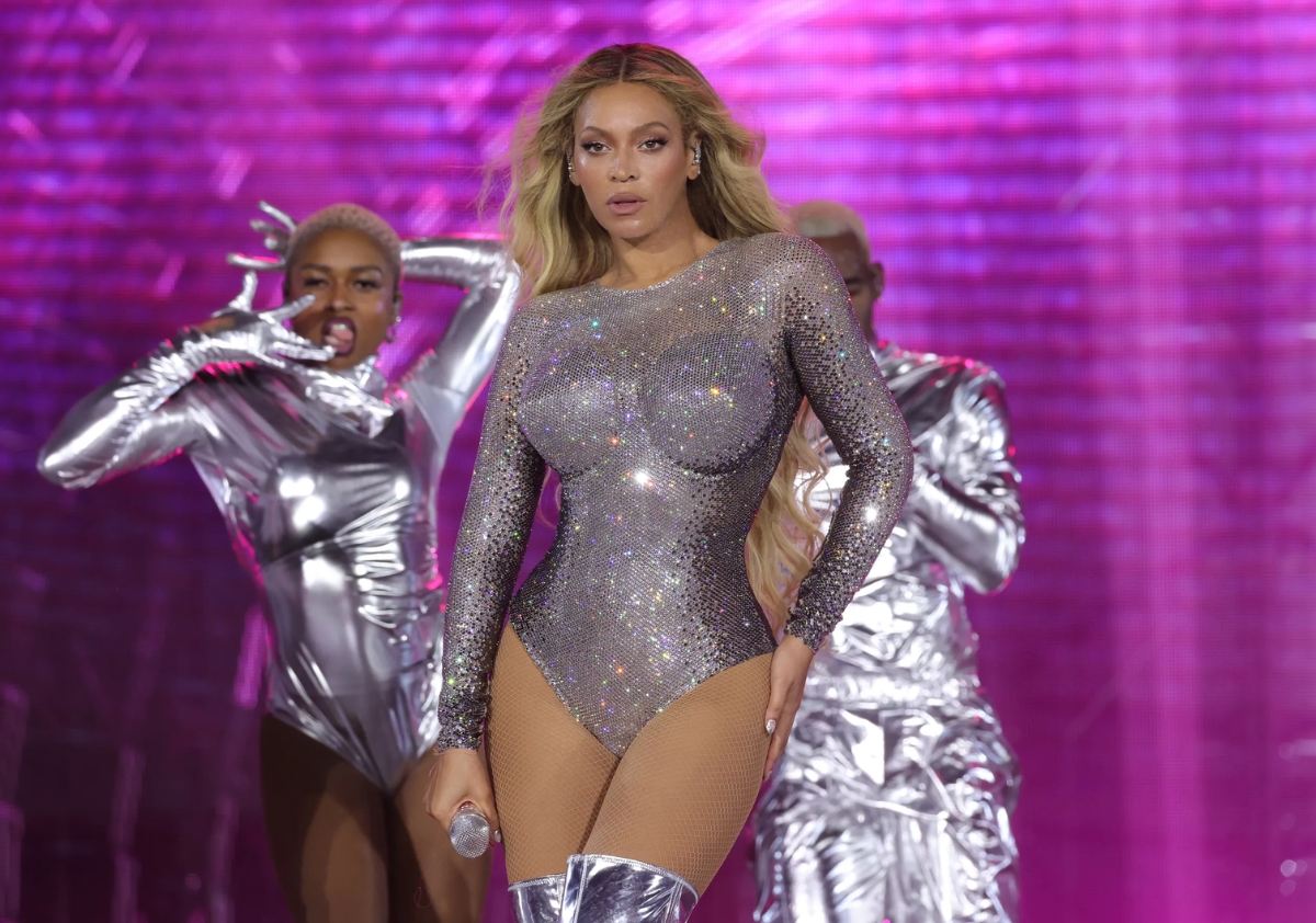 Beyonce standing in a power pose on stage in a silver bodysuit in a moment from her Renaissance world tour