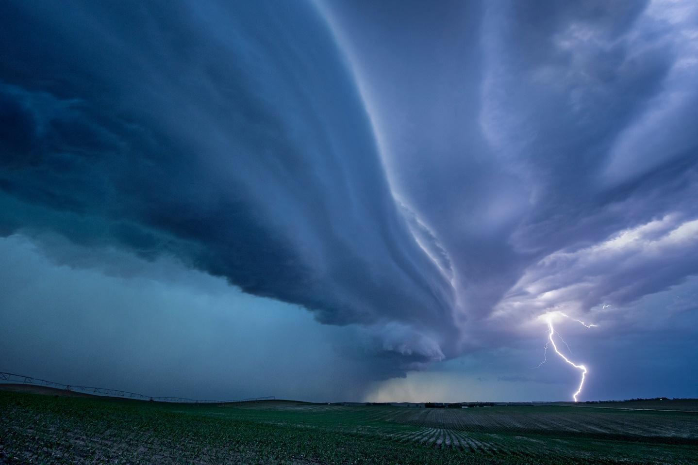 lightning striking beneath a picturesque supercell thunderstorm
