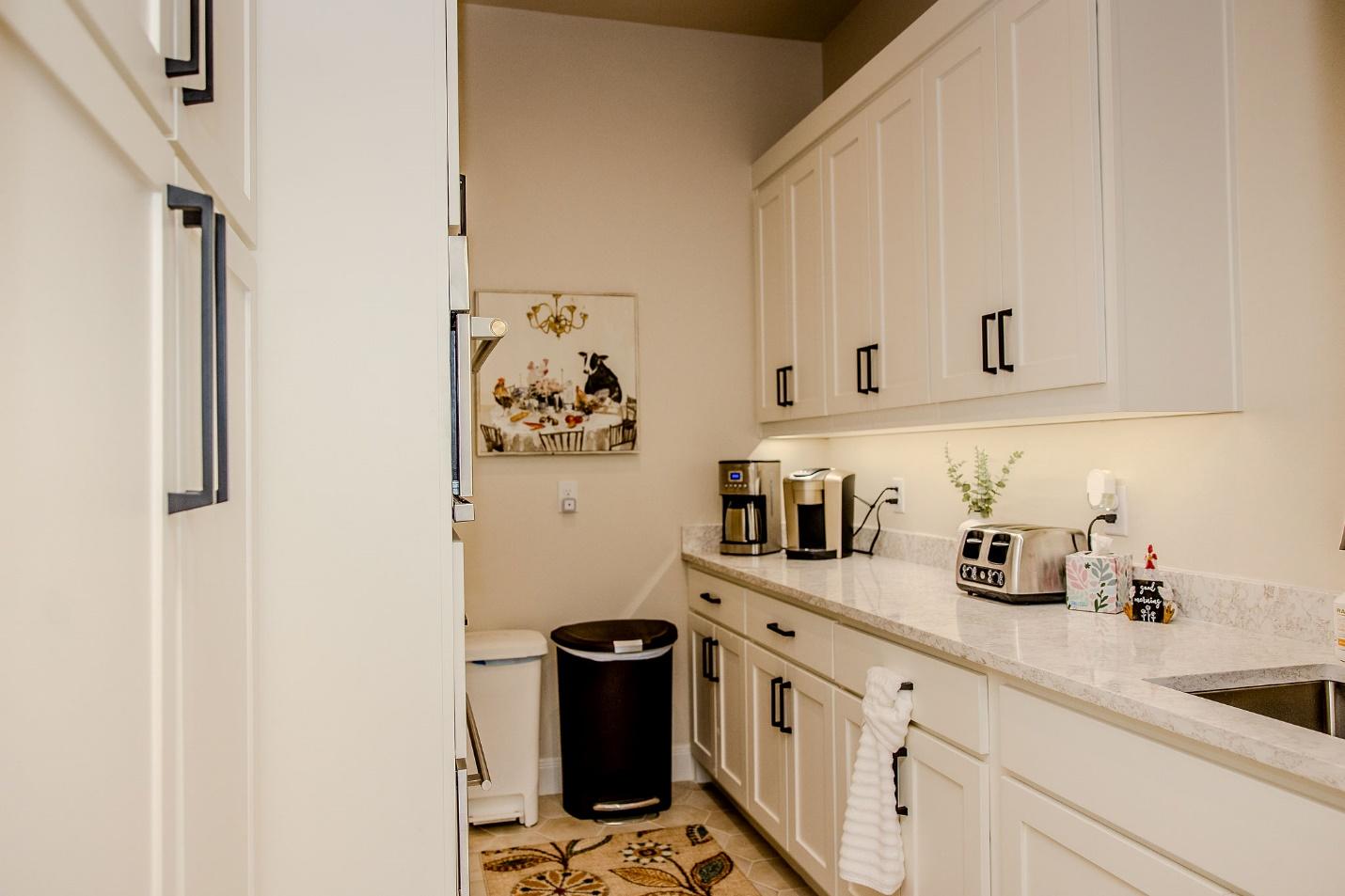 A kitchen with white cabinets and appliances

Description automatically generated