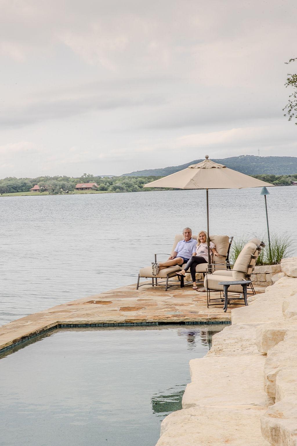 A person and person sitting on chairs by a pool

Description automatically generated