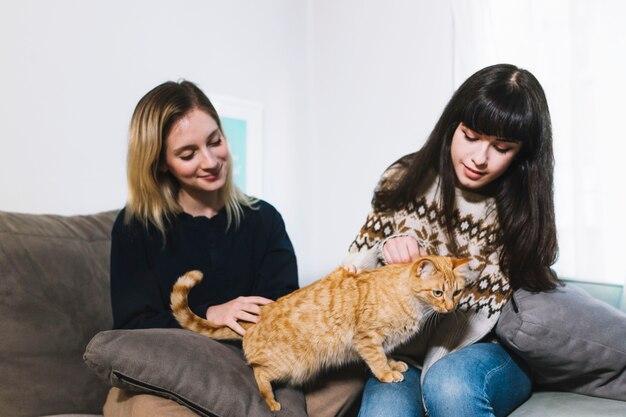 Charming girls cuddling with cat