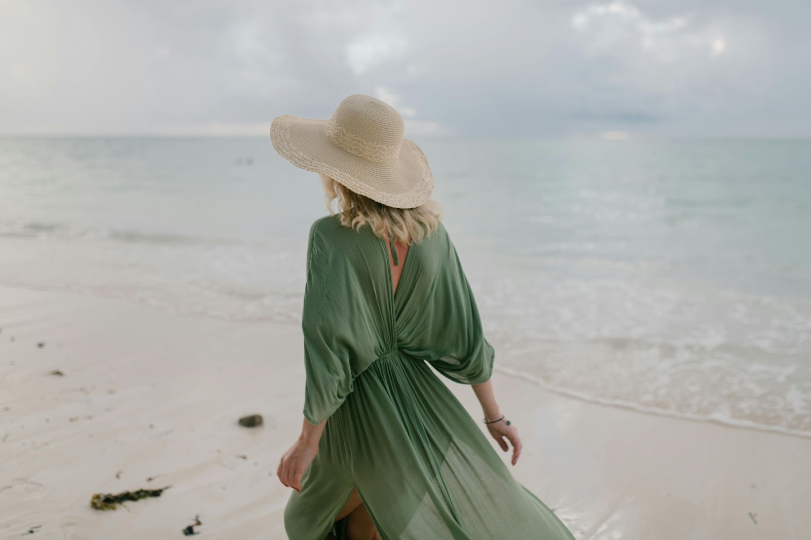 A woman wearing jewellery on the beach. 