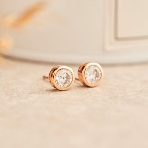 A pair of gold earrings with diamondsDescription automatically generated