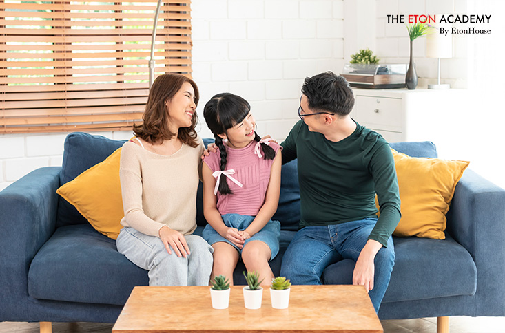 Asian Parent sitting on family couch having a pleasant conversation with daughter