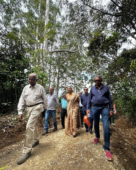 A group of people walking on a dirt path

Description automatically generated