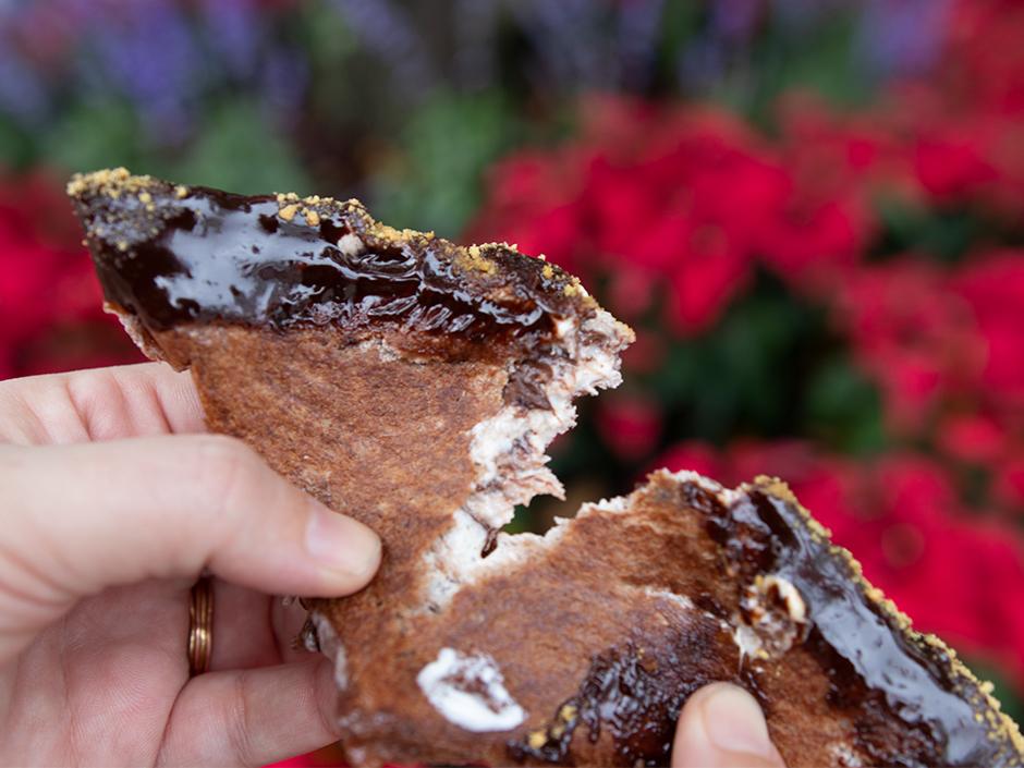 A hand holding a smore's sandwich