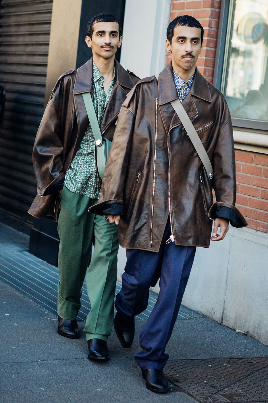 Full view of two guys dressed in leather coats for the fashion show 