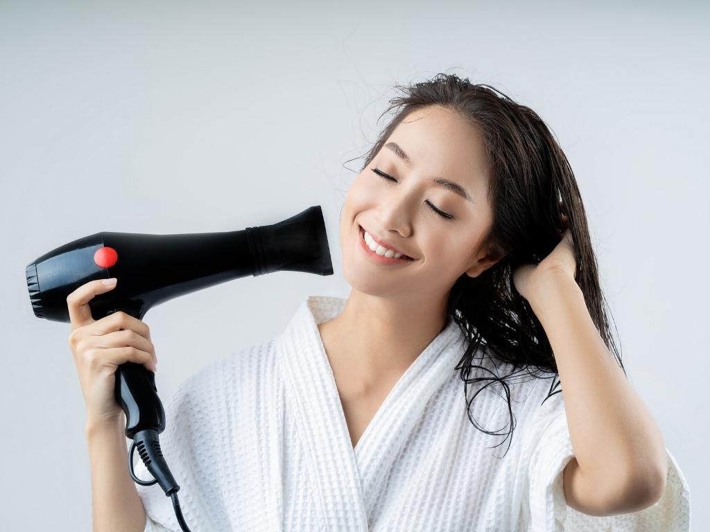 A person holding a hair dryer

Description automatically generated