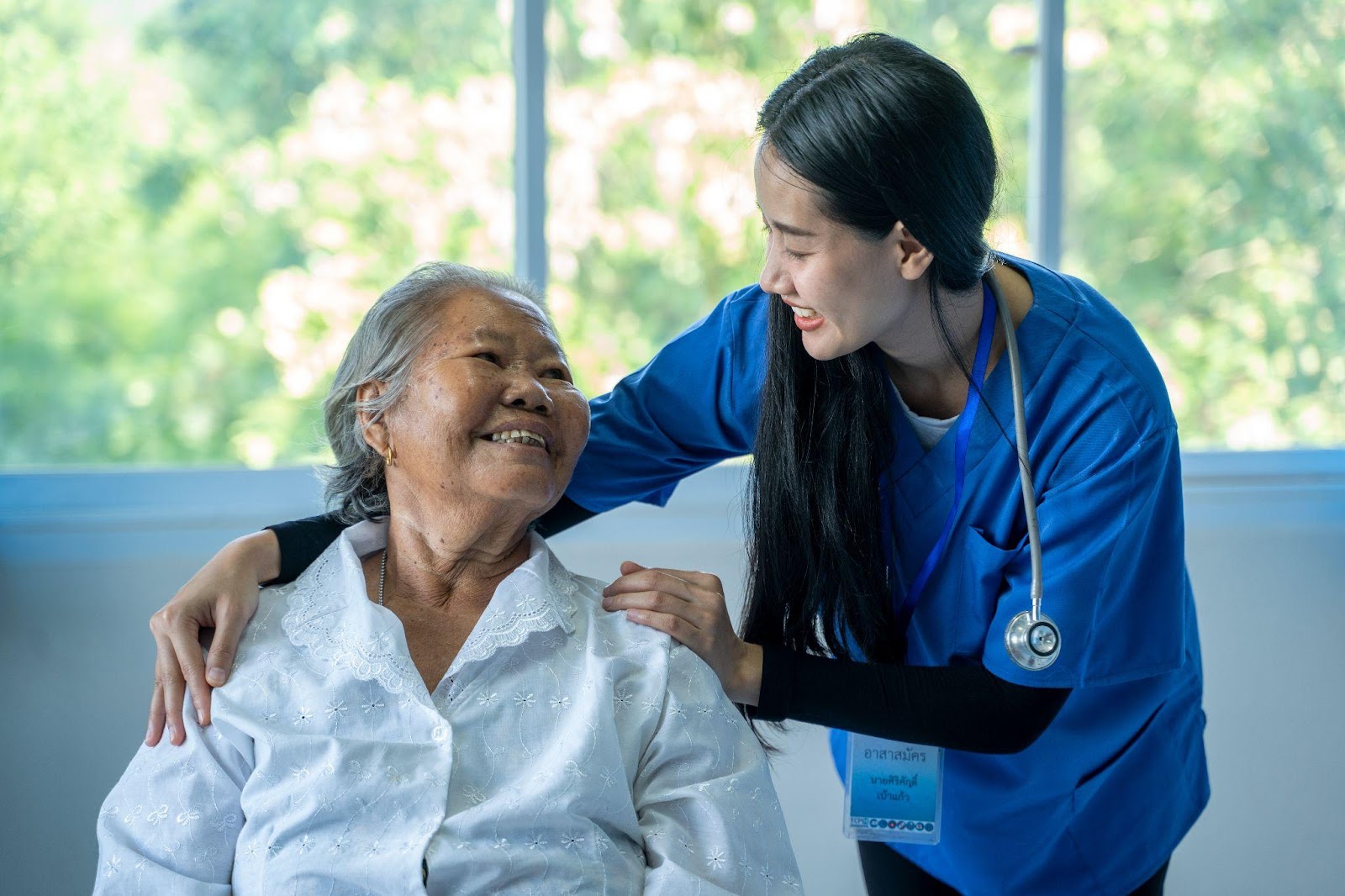 Nurse and senior woman laughing in an assisted living community