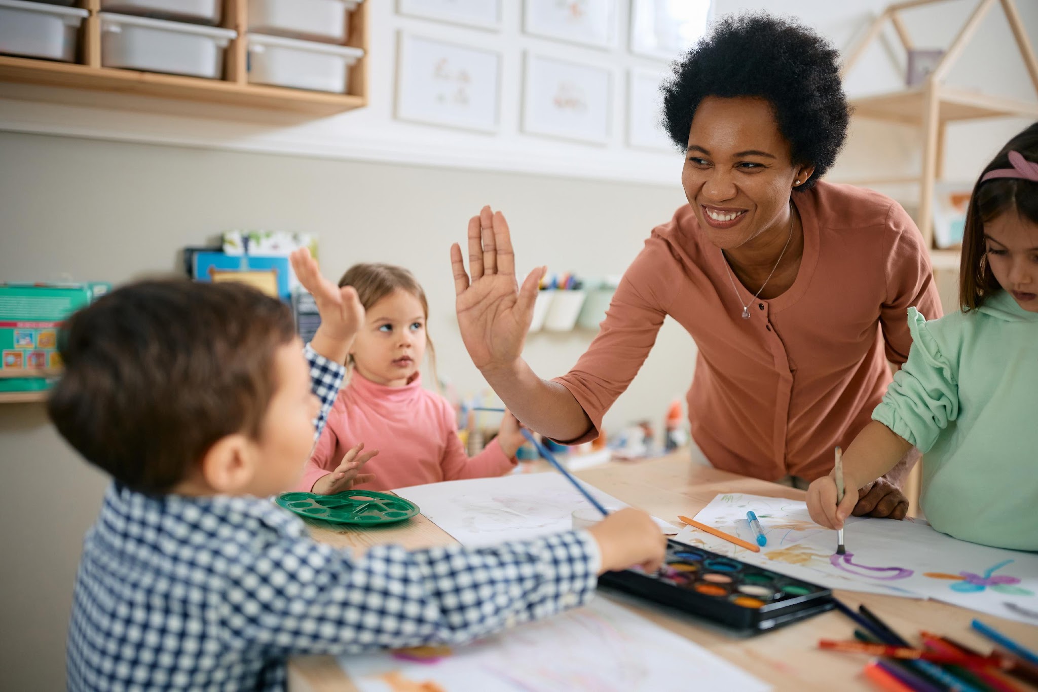 Teacher high-fiving young student