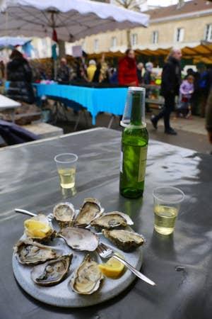 Oysters on a table at an open air market.