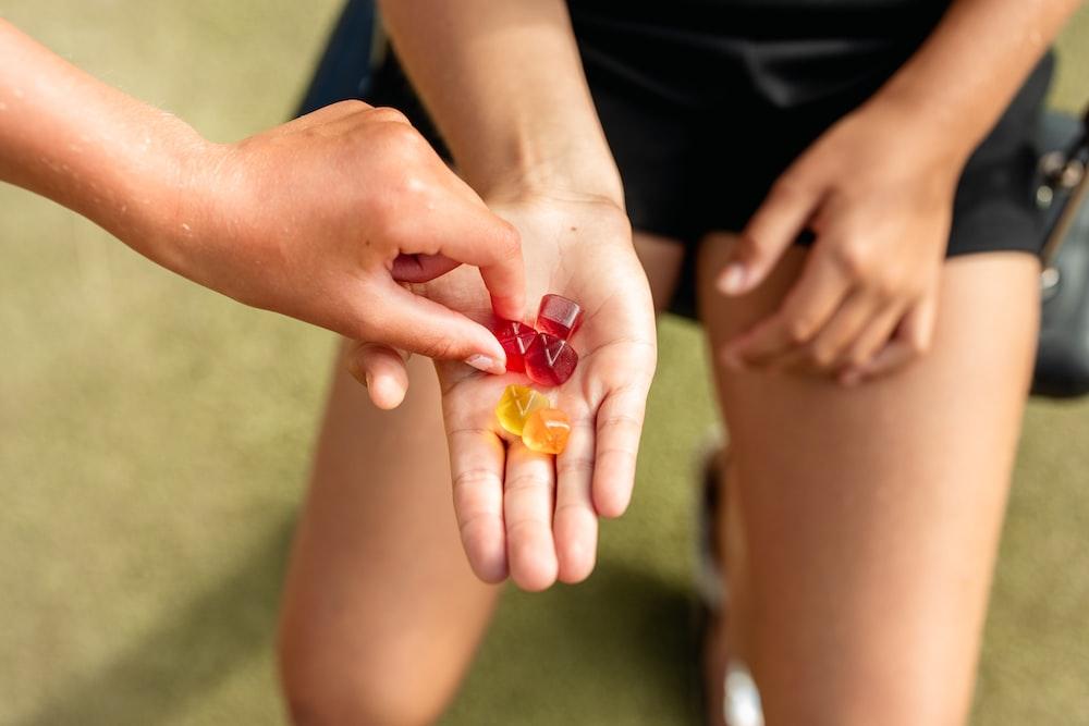 person holding orange and red beads